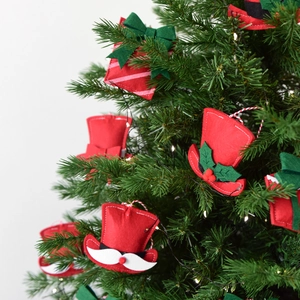 Mini felt Christmas gift boxes and hats hanging as ornaments on a green festive tree