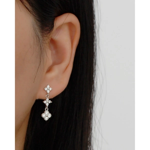 Close-up of S925 silver triple flower dangle earrings with cubic zirconia on model