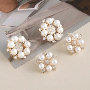 Elegant pearl and rhinestone floral earring set with gold base on a minimalist desk