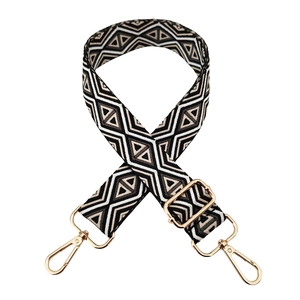 Detail of geometric rhombus wide bag strap with light gold metal lobster clasps and buckles
