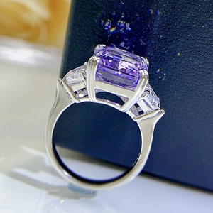 Macro shot of rectangular purple gemstone ring with white side stones in silver setting