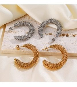 Détail des boucles d'oreilles spirales en forme de C dorées et argentées sur soie