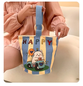 Close-up of canvas bucket bag with happy cat print, blue stripes and wooden handle