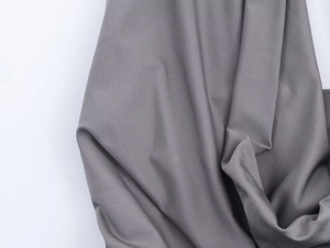 Close-up of charcoal grey knit fabric texture with soft drape for elegant maxi dress
