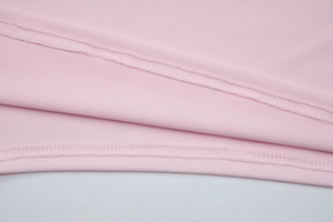 Detail of pink fabric showing professional double-needle stitching and smooth texture