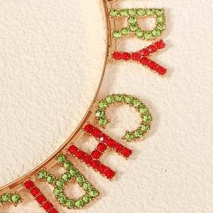 Macro detail of red and green rhinestone Merry Christmas letters on a gold metal headband