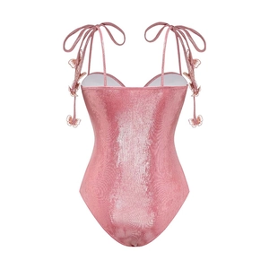 Detailed view of pink glossy swimsuit featuring 3D butterfly accents on the straps