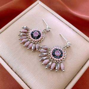 Vintage bohemian tassel earrings with pink and grey crystal beads on a satin background