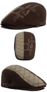 Detail view of canvas newsboy hat featuring vintage embroidery and adjustable metal buckle