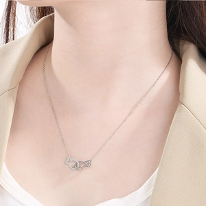 Dettaglio della collana in argento con pesci intrecciati e cristalli indossata