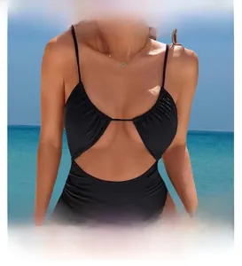 Detail of black cutout swimsuit with thin straps and ribbed texture on tropical beach