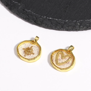 Detailed macro of gold celestial charms with purple glitter resin and star heart motifs