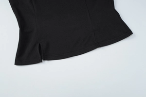 Détail de l'ourlet d'un crop top noir avec fentes latérales et coutures de précision