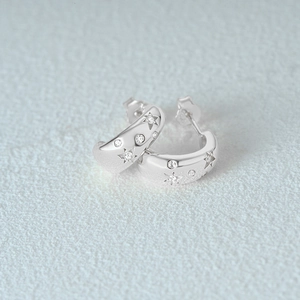 Macro shot of S925 sterling silver C-shape earrings with engraved stars and zircon stones
