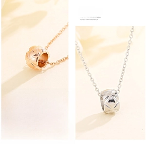 Macro detail of quilted pattern cylinder pendant necklaces in rose gold and silver finish