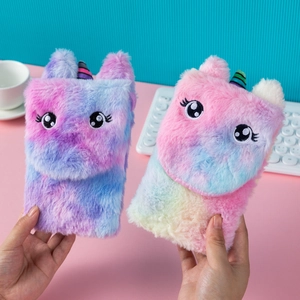 Close-up of fluffy unicorn plush notebook cover with detailed 3D ears and embroidery