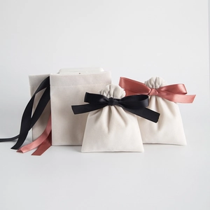 Detail of off-white velvet jewelry pouches with silk drawstring and bow closure