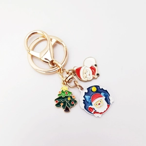 Detail of Christmas keychain with Santa Claus and tree charms in gold-tone metal enamel