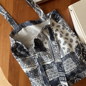 Détail de l'imprimé paisley bohème sur cabas en toile marine posé sur table en bois
