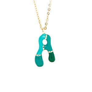 Artistic gold necklace with a green enamel letter A pendant on a white background