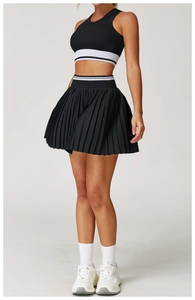 Detail of black pleated tennis skirt with striped elastic waistband and matching sports vest