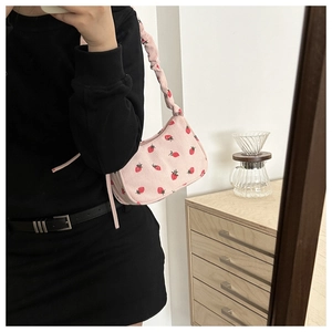 Detailed view of pink corduroy shoulder bag with strawberry embroidery and pleated handle