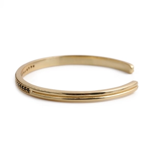 Elegant gold open bangle featuring a row of micro-set black zircons on a metallic band