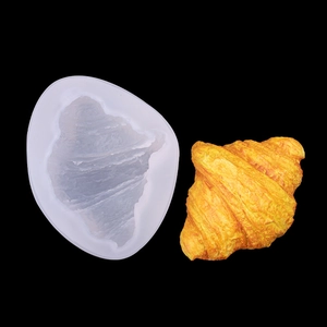 Macro view of translucent silicone mold showing detailed croissant texture and final pastry