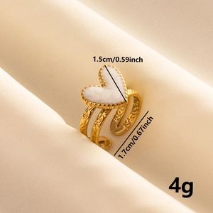 Detail of gold heart ring showing dimensions 1.5cm and 1.7cm on beige fabric
