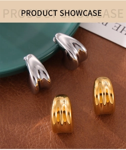 Detail of minimalist gold and silver double-layered teardrop earrings on leather