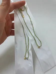 Detail of olive green beaded necklace with gold and silver balls on stainless steel chain