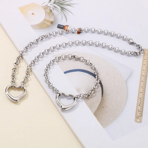 Set collana e bracciale con ciondolo a cuore in perle e righello su sfondo bianco