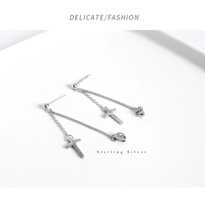 Macro shot of sterling silver cross pendant ear chain with delicate chain texture