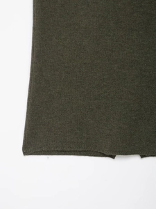 Dettaglio della maglia e dell'orlo a coste sul set in maglia verde scuro da donna