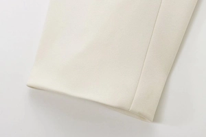 Close-up of premium beige fabric texture and precise stitching on an elegant suit