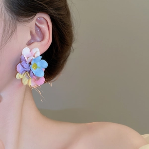 Close-up detail of oversized colorful chiffon flower earrings for summer beach style