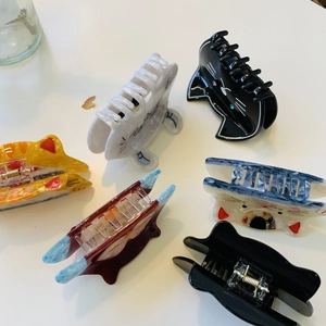 Detail of assorted cat-shaped acetate hair claws featuring diverse patterns and colors