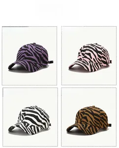 Detail view of four zebra print baseball caps in purple, pink, white, and brown colors