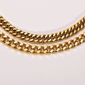 Detail of gold-plated Cuban and Figaro chain link bracelets with high polish finish