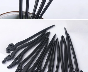 Detailed macro view of ebony wood hairpins with carved cloud patterns and sleek finish