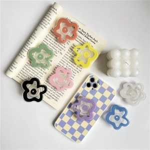 Macro shot of colorful transparent floral pop socket phone grips on a checkered case