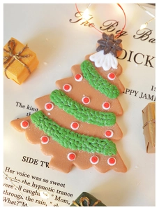 Detailed close-up of a Christmas tree clay ornament on a warm background with festive decor