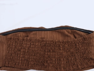Detail of brown tube top featuring non-slip silicone strip and elastic smocked fabric