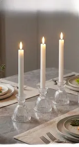 Macro shot of vertical ribbed glass candle holder set with white taper candles