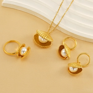 Elegant gold shell jewelry set with white pearls including necklace, earrings and ring