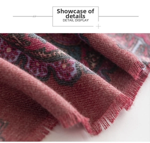 Close-up of red paisley pattern on thick woven scarf featuring fine fringe details