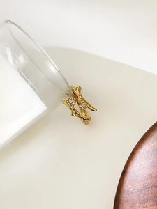 Detailed close-up of golden lava texture ring with two zircon stones on stone background