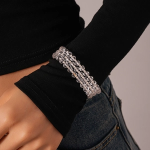 Detailed macro view of triple-layered glass bead bracelet on a model's wrist