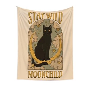 Detail of bohemian tapestry featuring Stay Wild Moonchild text and celestial cat artwork