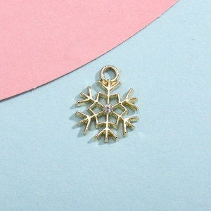 Detailed view of a gold snowflake pendant with a central sparkling rhinestone